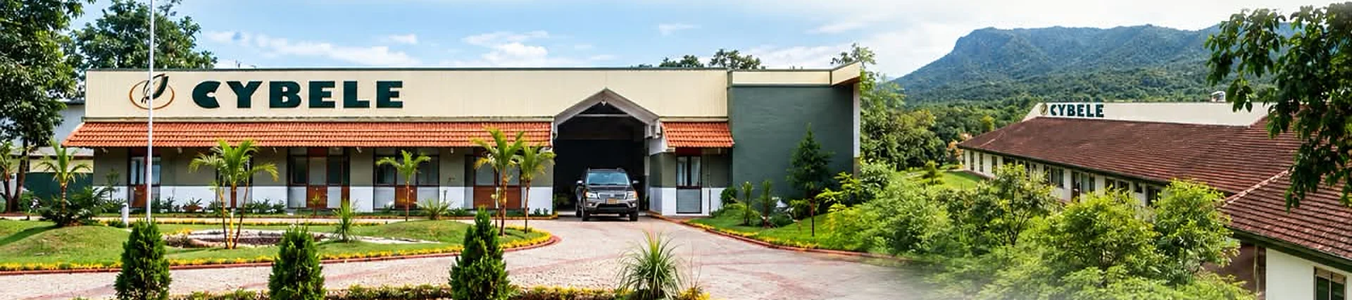 The Cybele manufacturing facility: the main building with the Cybele name over the entrance, gardens in front, a second block and wooded hills behind