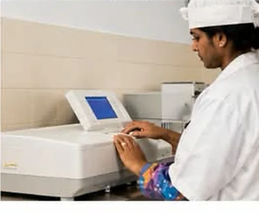 An analyst working at a laboratory instrument