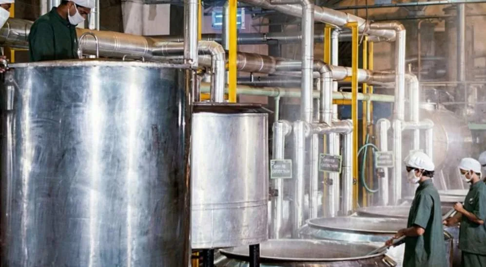 Stainless steel production vessels at the Cybele factory, with staff in uniform